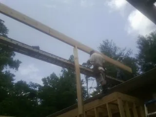 Carpenter setting a ridge beam over a new addition frame — Ice Dam Removal by Roofing Brothers in Park City